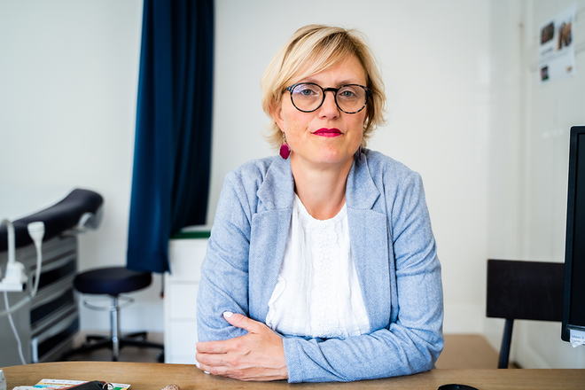 Sofie Merckx assise à son bureau dans son cabinet médical.