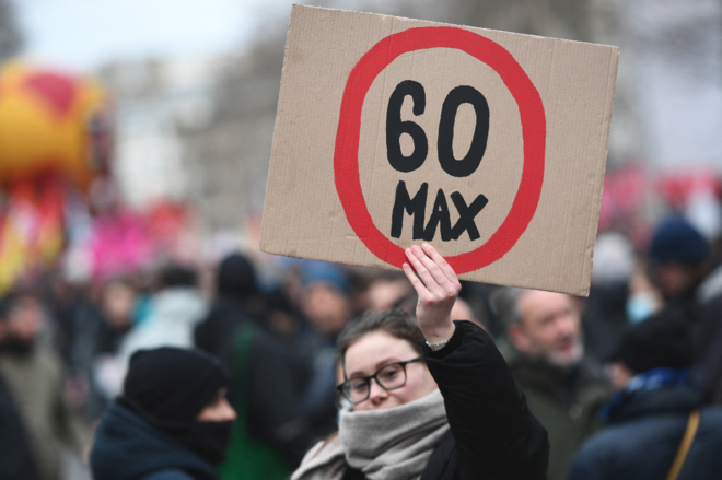 Une manifestante brandit une pancarte avec écrit "60" cerclé de rouge.