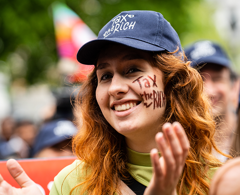 Une femme porte une casquette avec l'inscription "Tax the rich" lors d'un rassemblement du 1er Mai du PTB.
