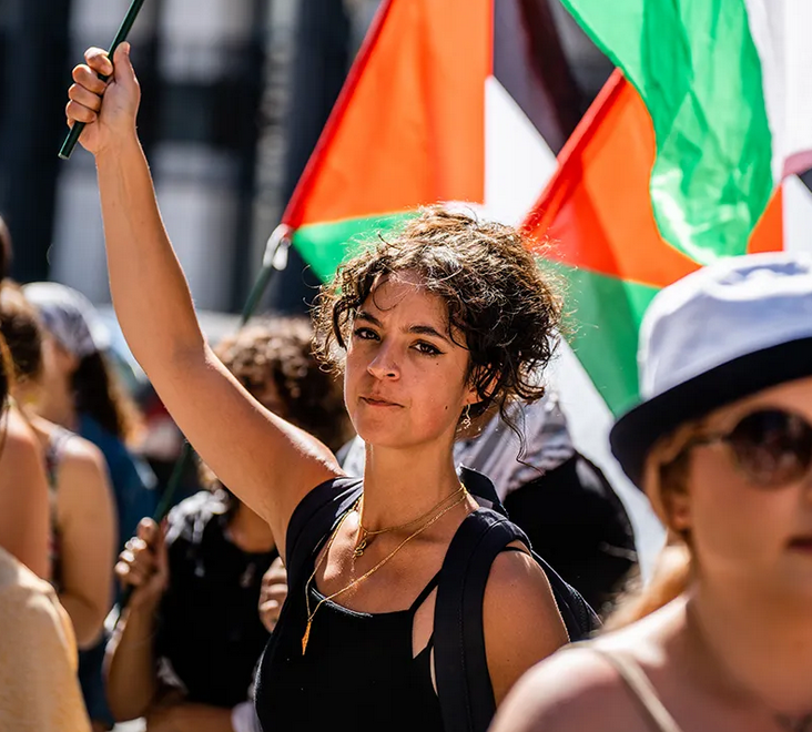  Een jonge vrouw houdt een Palestijnse vlag vast tijdens een solidariteitsbijeenkomst met Palestina. 