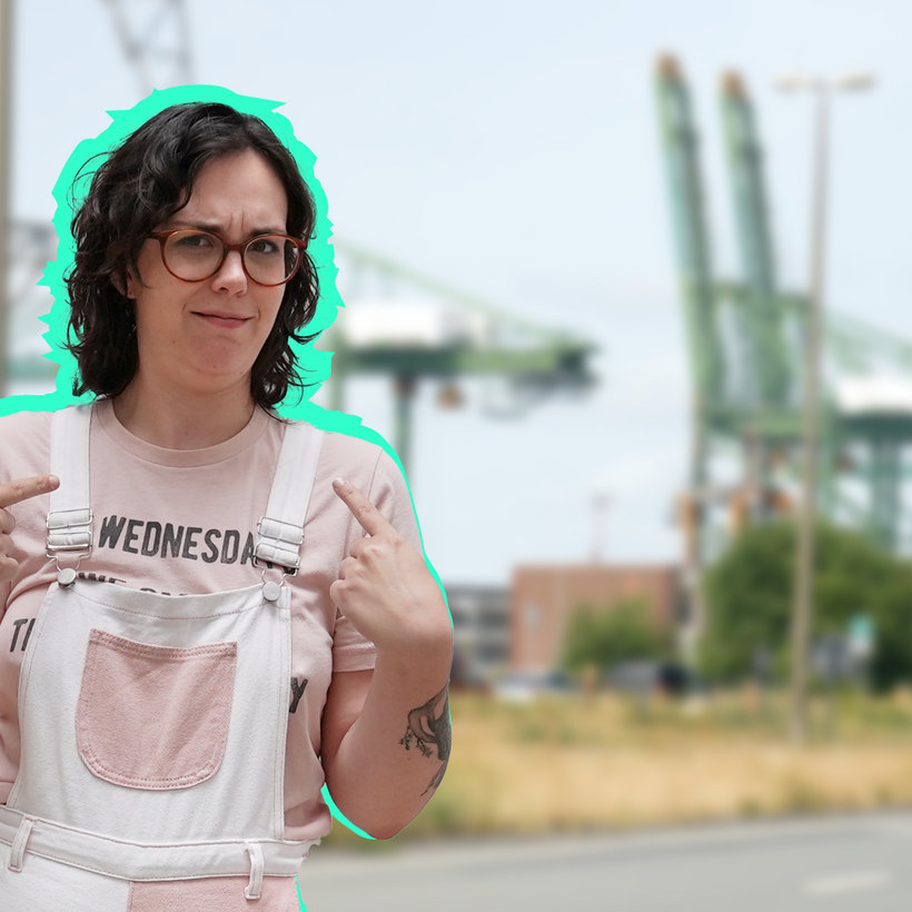 Lilo van Fakto wijst naar zichzelf en kijkt verbaasd. De achtergrond is de haven van Antwerpen.
