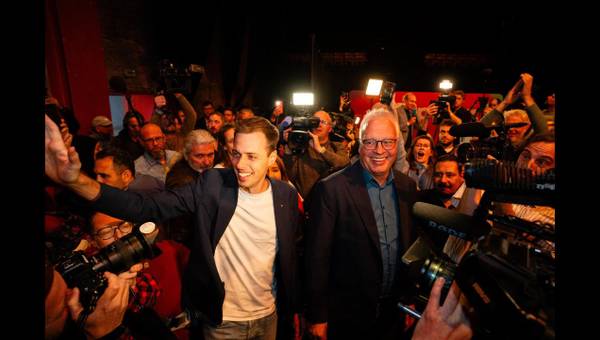 Jos D’Haese en Peter Mertens komen de zaal binnen van de verkiezingsavond in Antwerpen