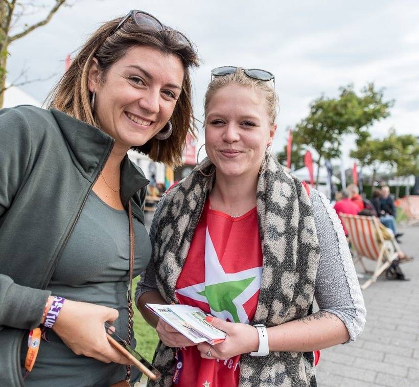 Twee leden van de PVDA glimlachen.