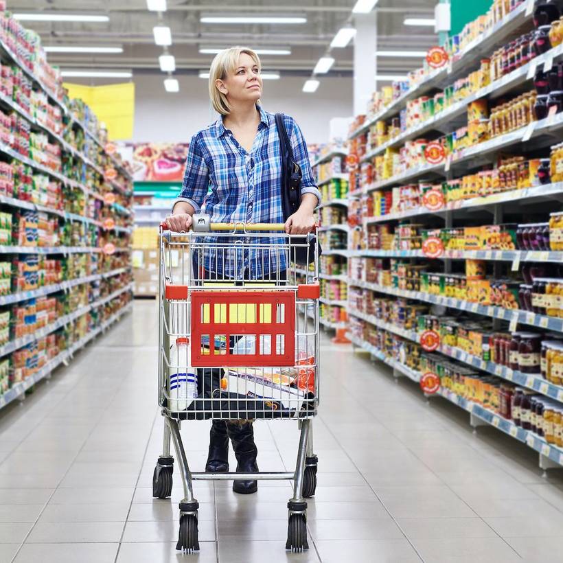 Vrouw met winkelkar in de supermarkt