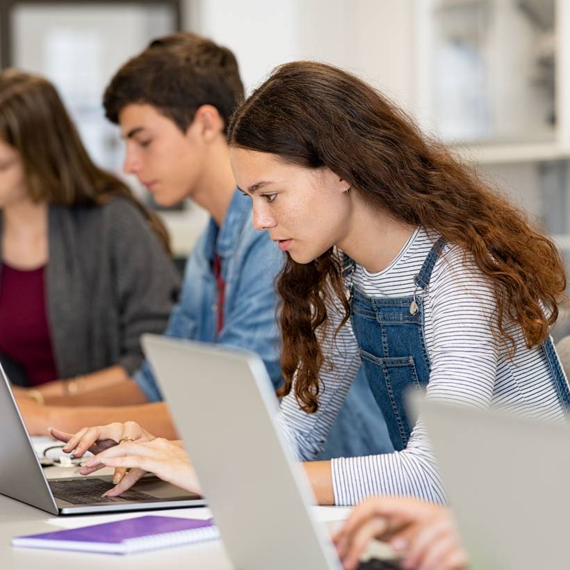 Étudiante en classe avec son ordinateur.