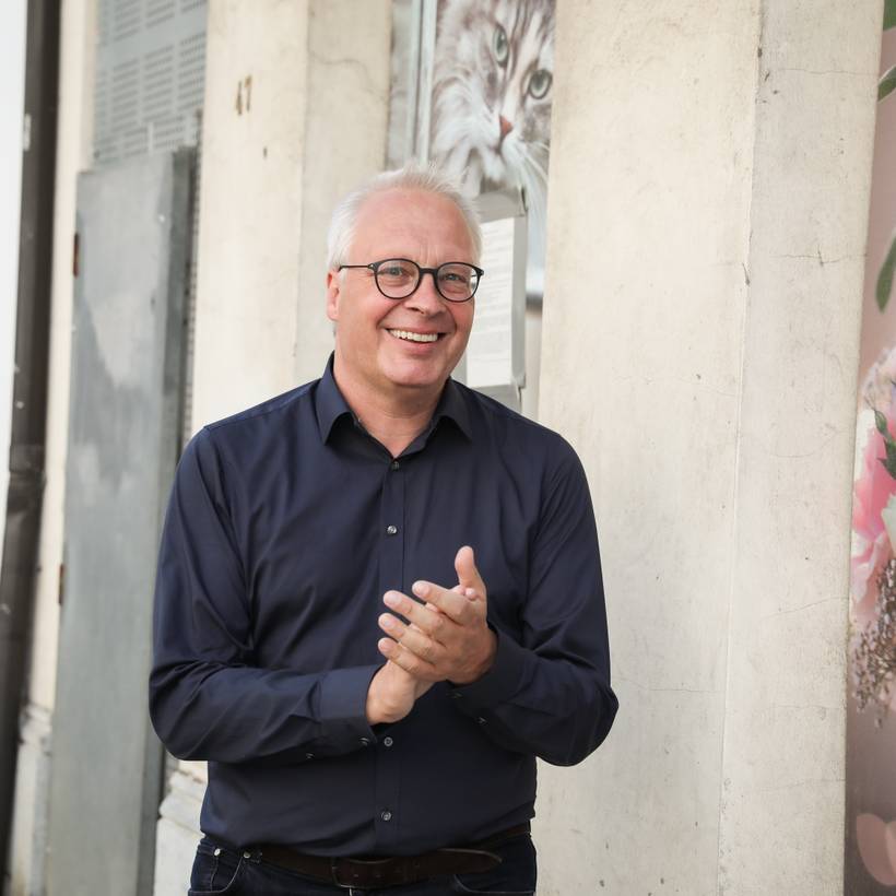 Een lachende Peter Mertens, fractieleider van de PVDA in de Antwerpse gemeenteraad