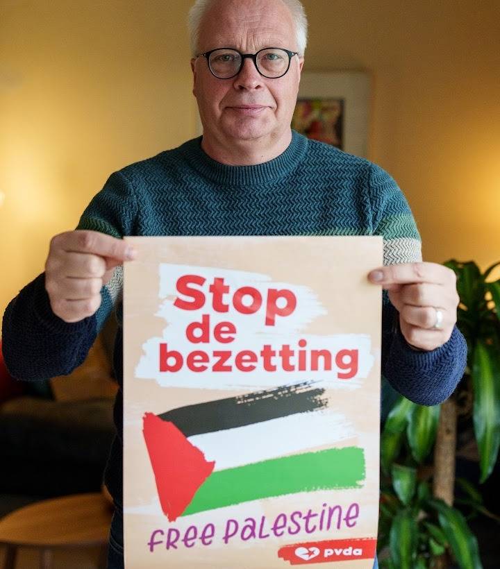 Peter Mertens houdt een poster vast die oproept tot het beëindigen van de bezetting van Palestina.