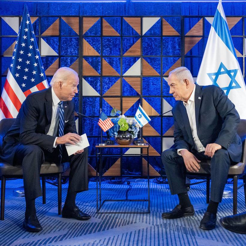 Joe Biden en Benjamin Netanyahu pratend voor de vlaggen van de Verenigde Staten en Israël