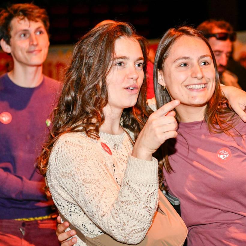 foto van twee jonge vrouwen die in dezelfde richting kijken. 