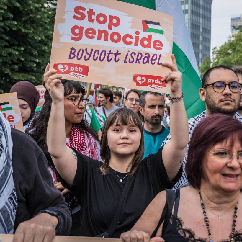 Photo d'une jeune femme en manifestation tenant une pancarte "Stop genocide, boycott Israel"