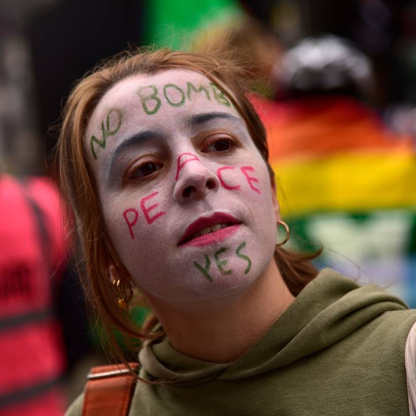 Jonge vrouw op een vredesbetoging, met op haar gezicht geschminkt: “No bombs, peace yes”