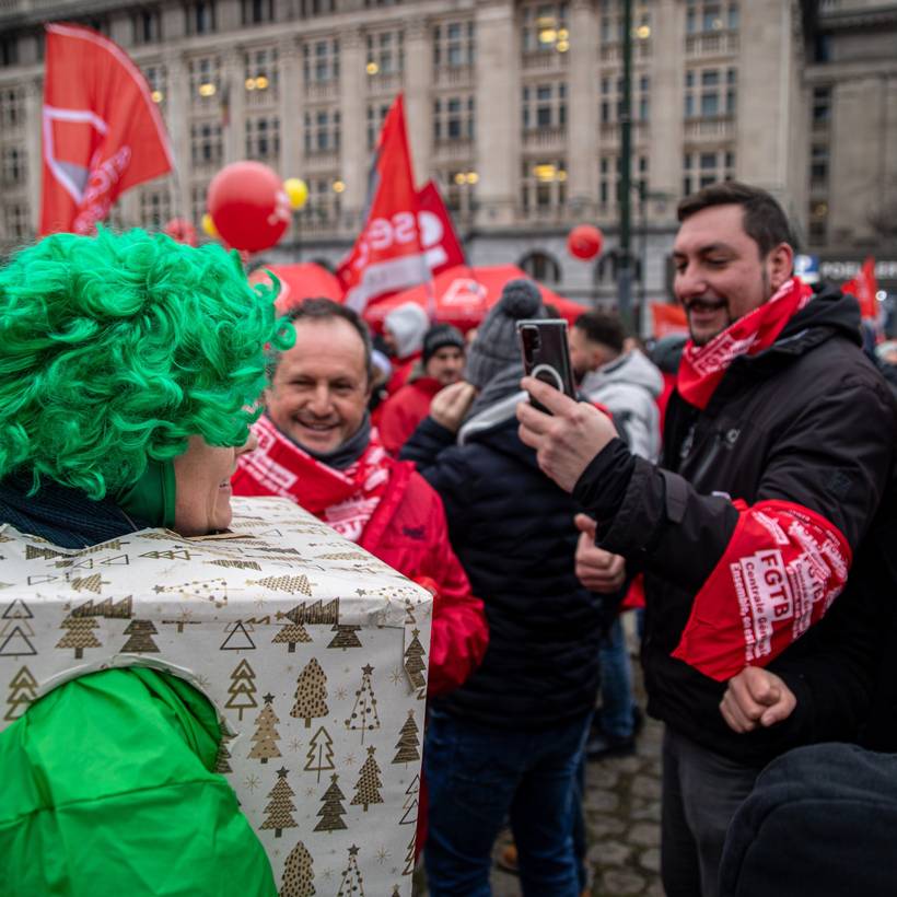 Des syndicalistes rouges prennent une verte déguisée en cadeau de Noël.