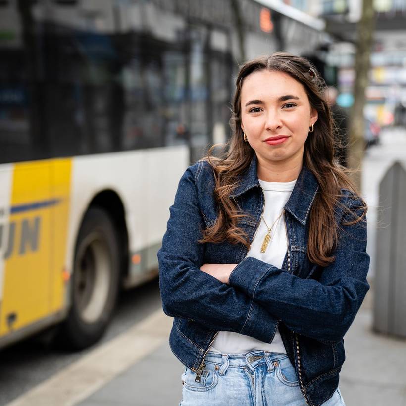 Amina Vandenheuvel poseert voor een bus van De Lijn