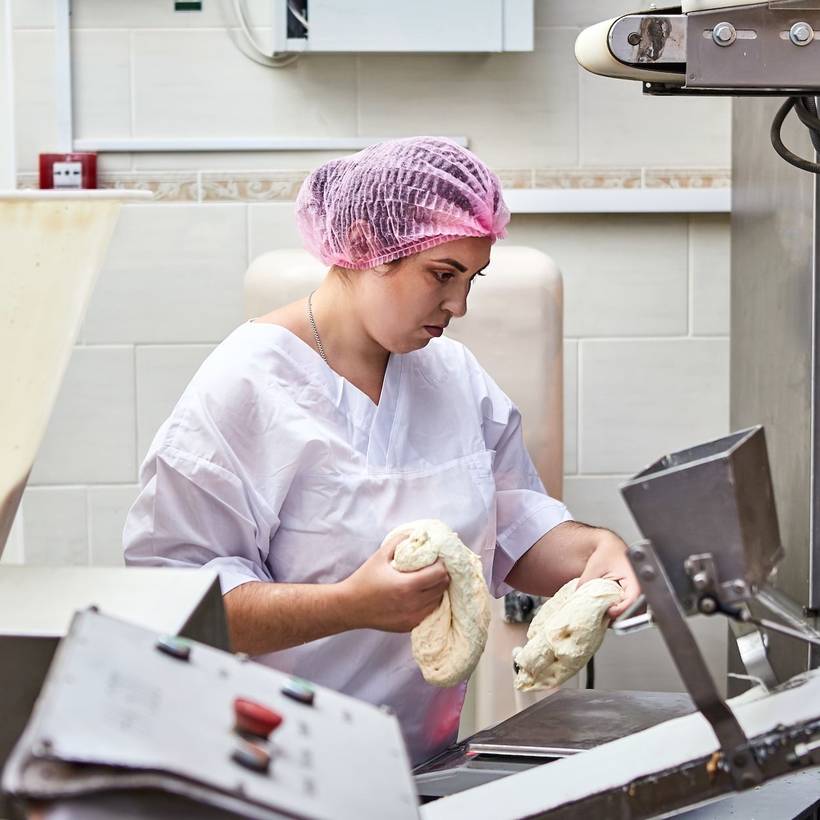 Vrouw aan het werk in een industriƫle bakkerij