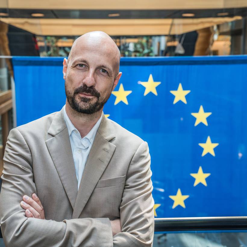 Marc Botenga pose devant un drapeau européen