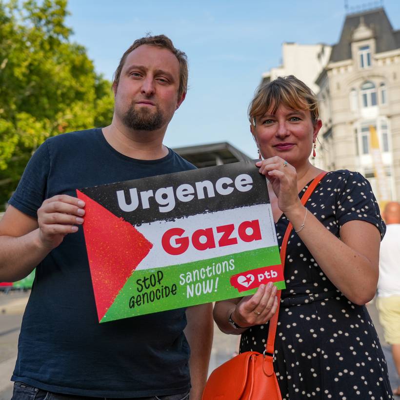 Deux personnes tiennent une affiche "Urgence Gaza".