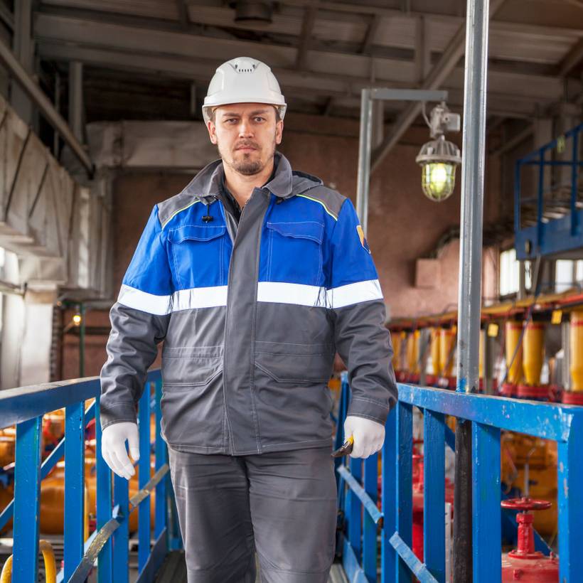 Un ouvrier dans une usine regarde la caméra