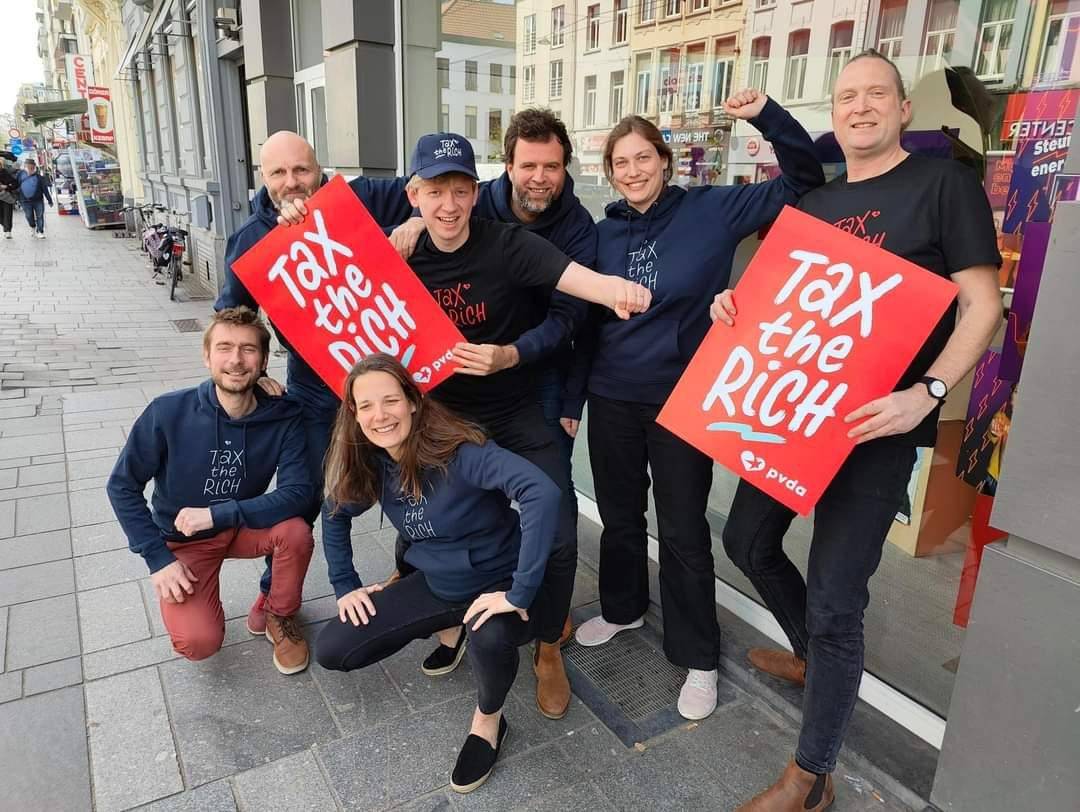 PVDA-leden in actie met borden met de tekst "tax the rich".
