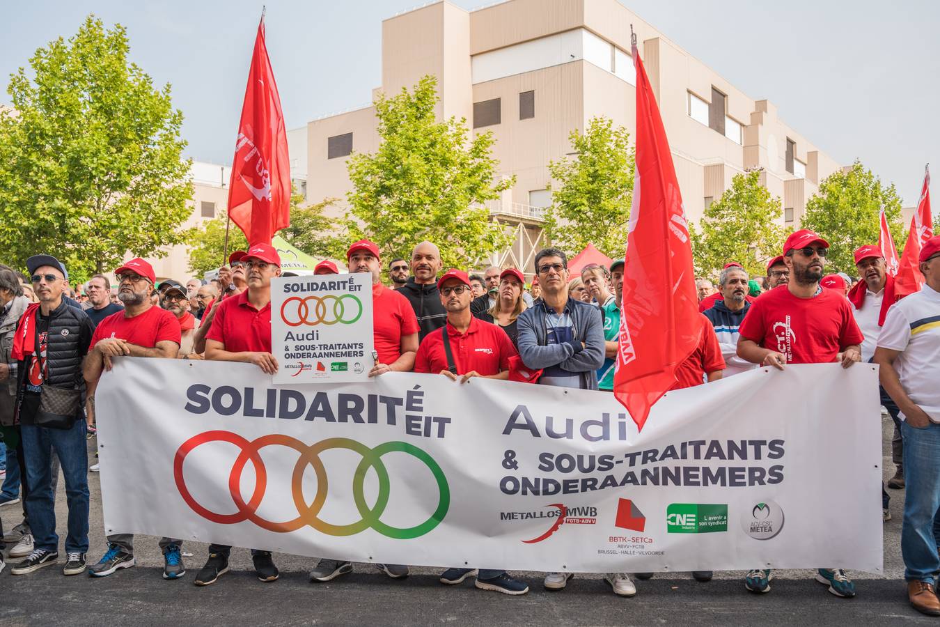 Arbeiders verzamelen zich met een spandoek voor de Audi fabriek in Brussel