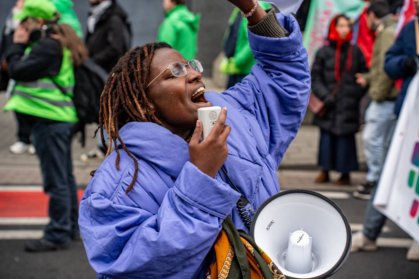 vakbondsbetoging 13 februari: een vrouw spreekt in een megafoon