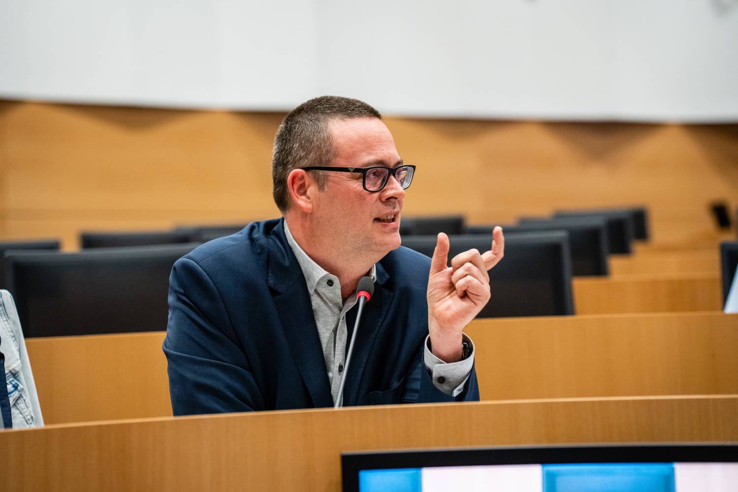 Raoul Hedebouw in het parlement. Hij maakt een gebaar met zijn handen terwijl hij praat.