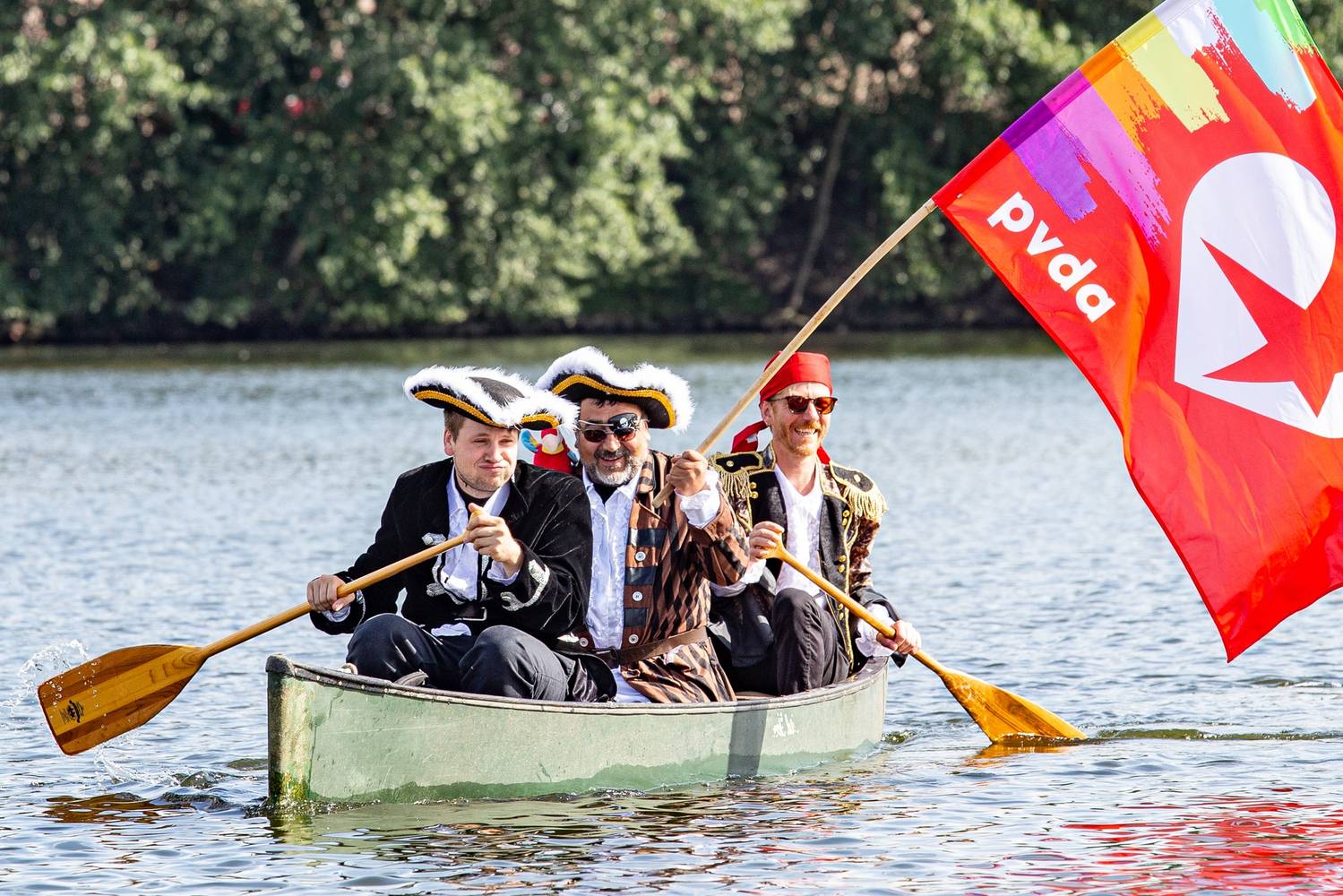 PVDA-leden verkleed als piraat komen in een kano aangevaren om mee te protesteren tegen de komst van een jachthaven aan het Houtdok in Gent